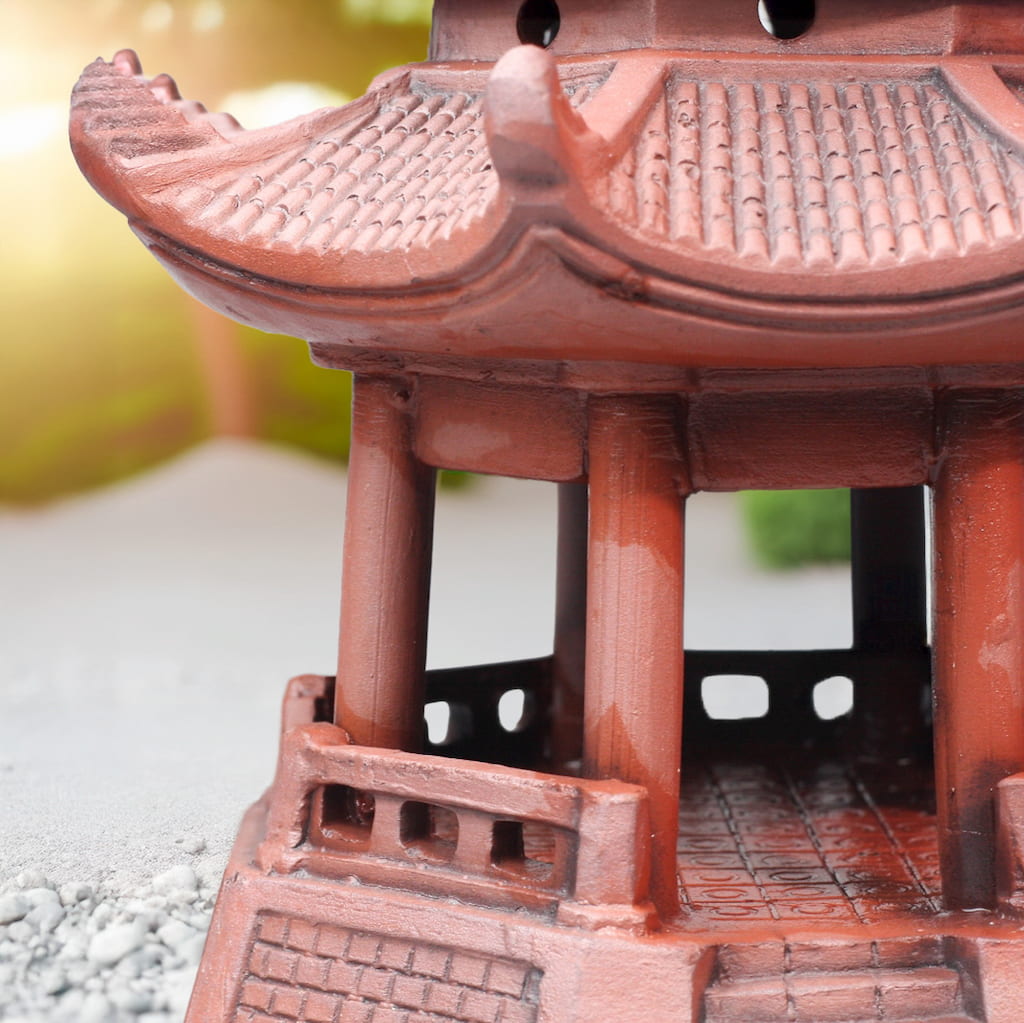 Side view: reddish-brown miniature pagoda for bonsai. Bonsai figurines like this enhance Zen style.