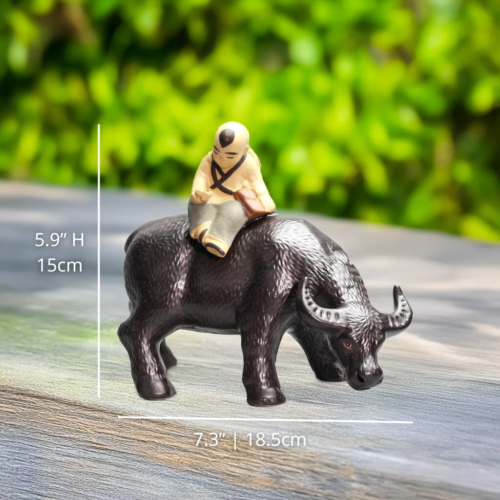 Figurine of a person riding a buffalo with measurements on a wooden surface