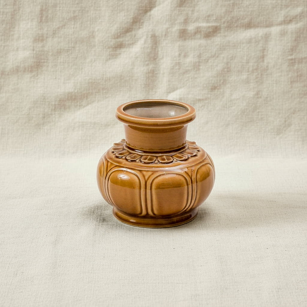 A brown handmade ceramic flower vase with a glossy finish. This low wide flower vase is artisan made.
