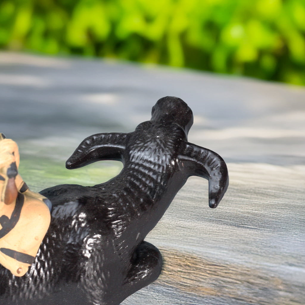Close-up: textured back of a black buffalo sculpture. Part of a cute water buffalo figurine.