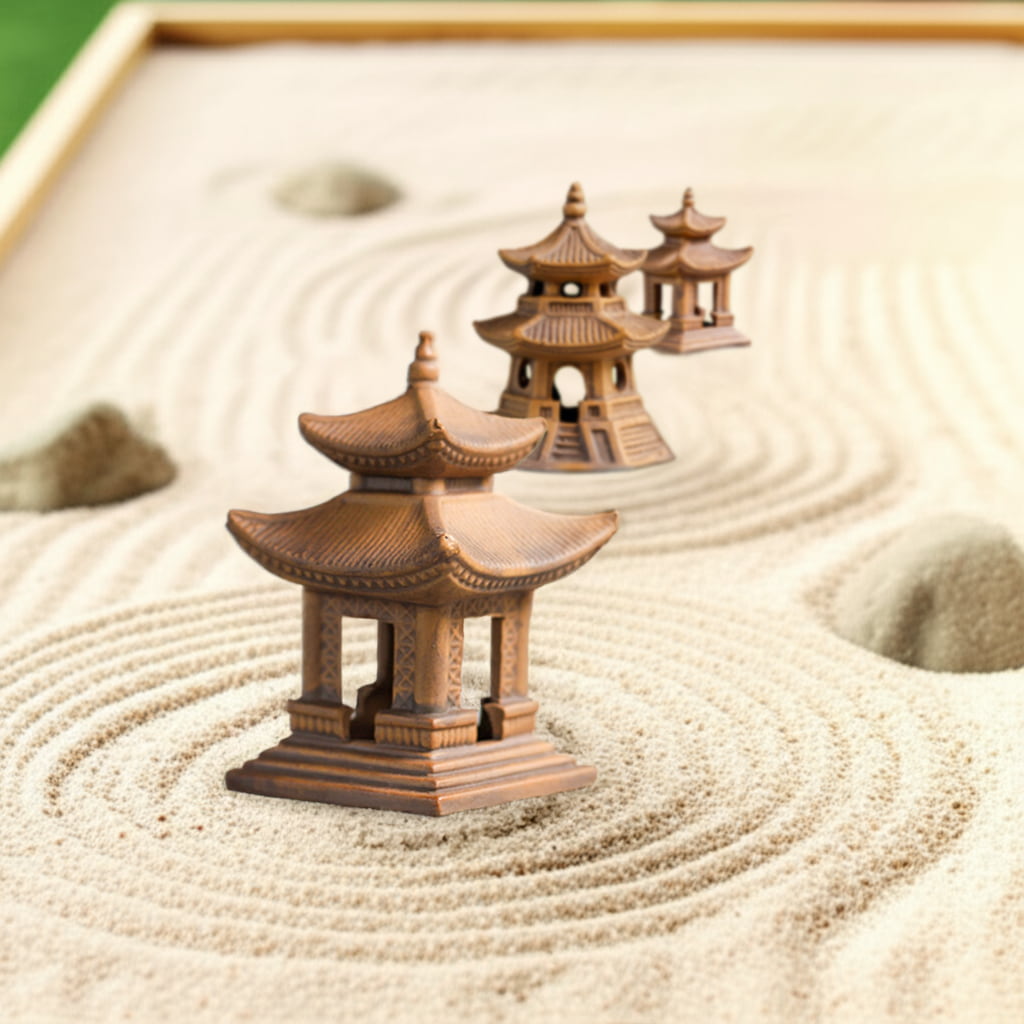 Three handcrafted pagoda statues arranged in sand, perfect Zen garden decor as Zen garden pagoda statue.