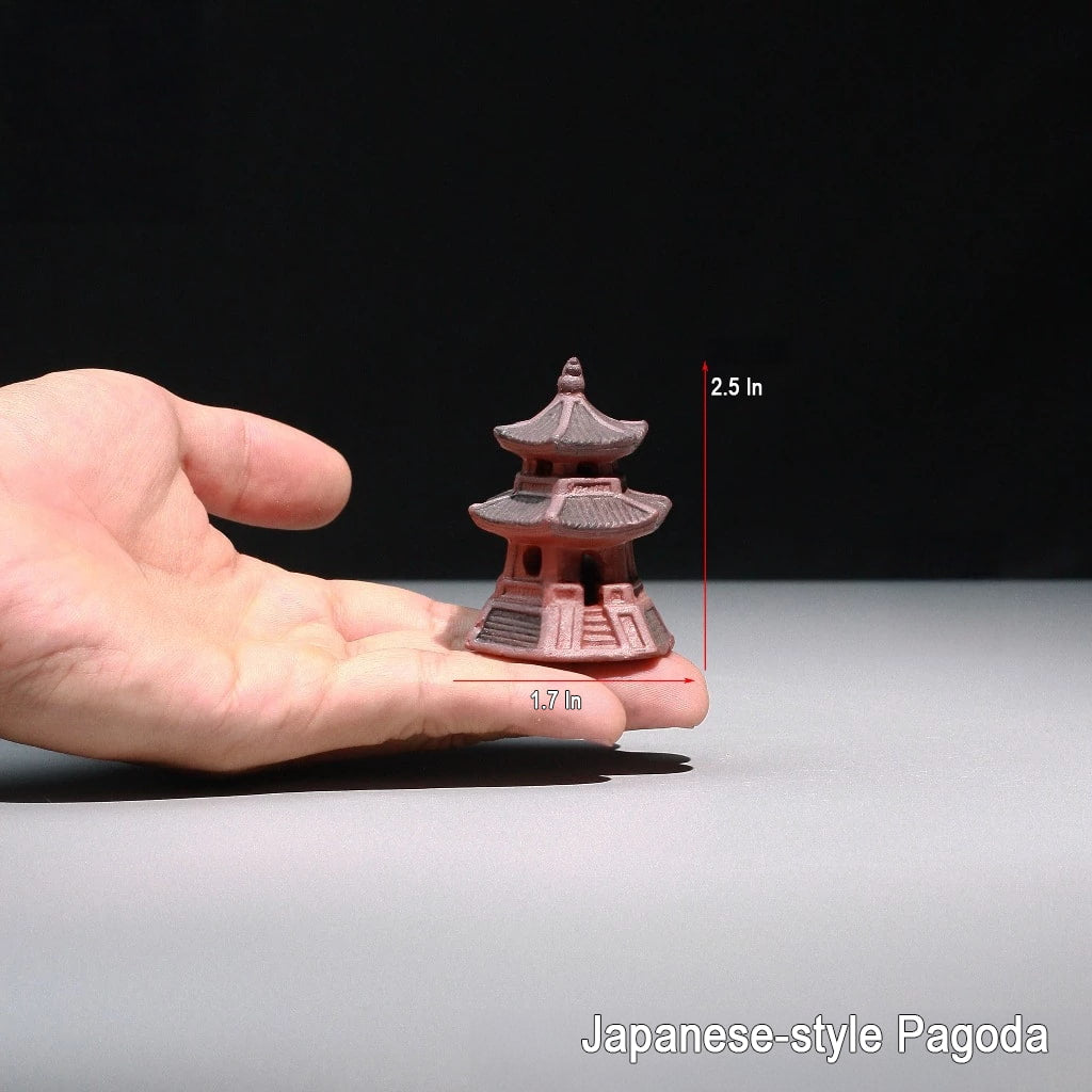 A hand holds a small, brown, multi-tiered miniature pagoda, 2.5 inches high. This pagoda statue is ideal as bonsai figurines.