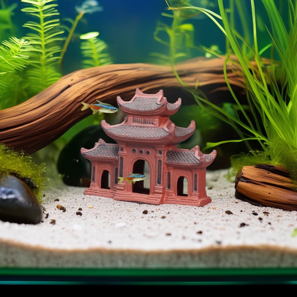 A miniature reddish-brown ceramic fish tank decor name three entrance gate sits on the sandy bottom of a fish tank, surrounded by green aquatic plants, driftwood, and small, colorful fish swimming around.