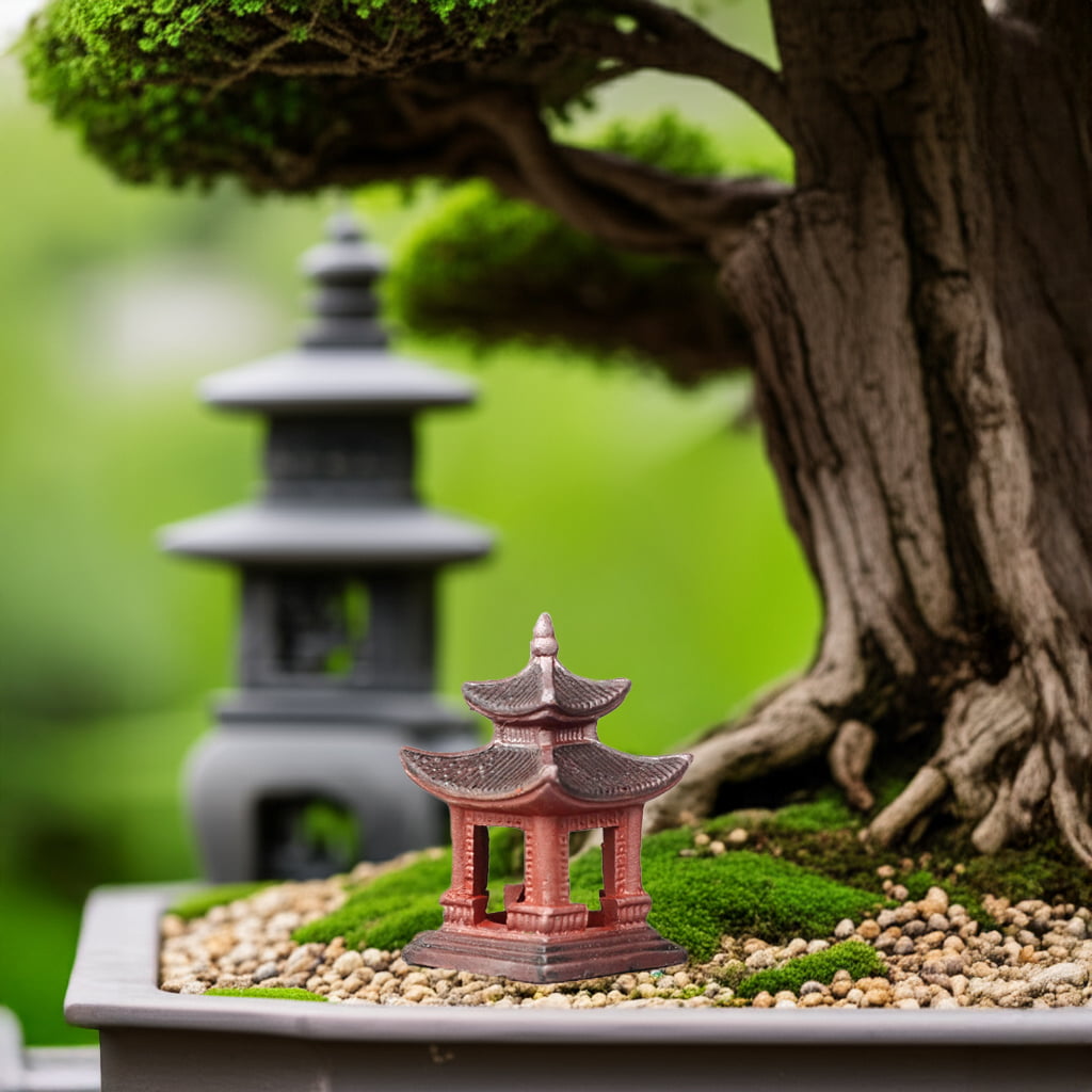 Small red bonsai figurine pagoda, a bonsai decor piece, by a tree. Grey pagoda blurred.