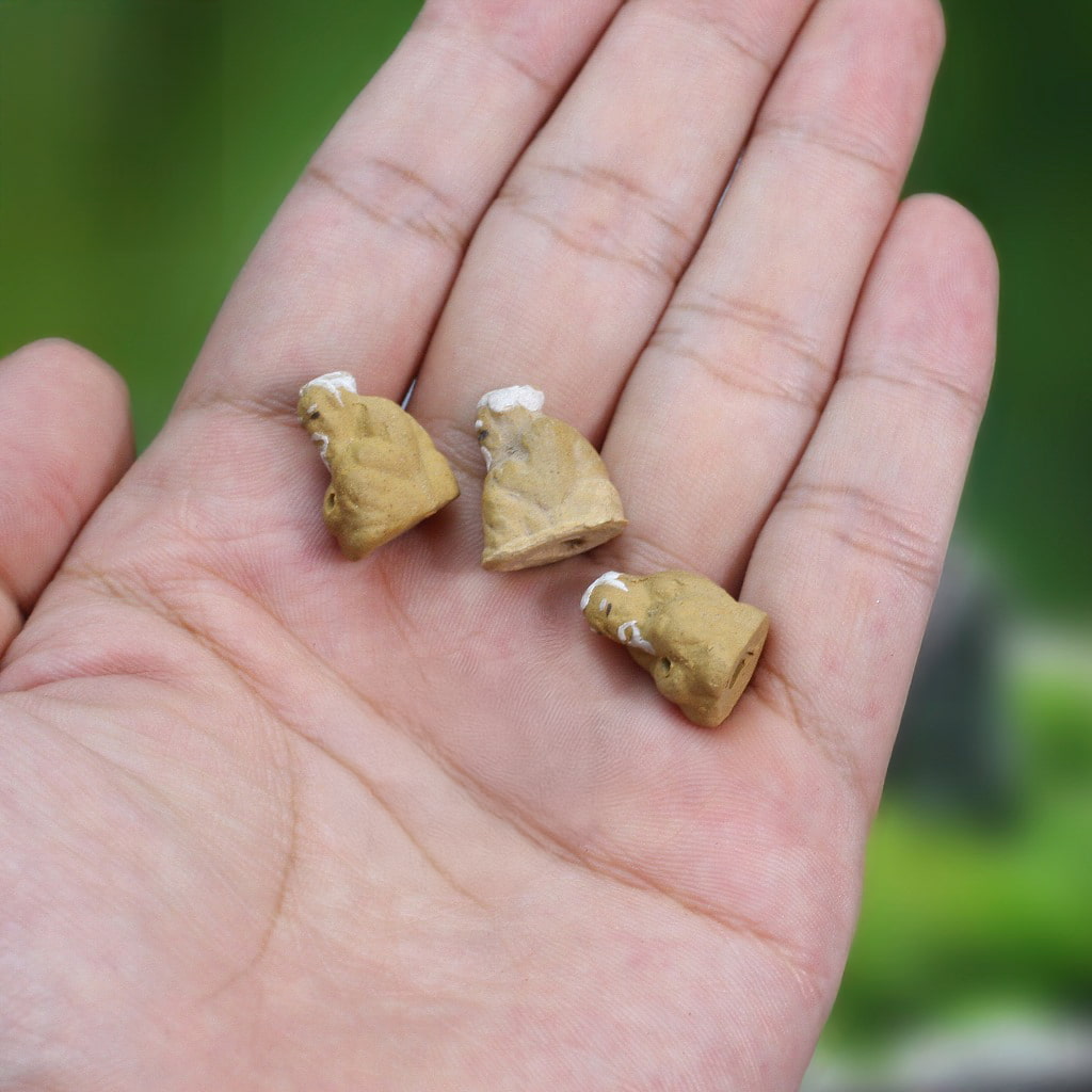 3 miniature ceramic mudmen fisherman figurine on a person's hand