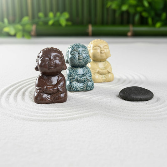 Three small buddha statues in brown, blue, and cream. A buddha figurine set for a zen garden