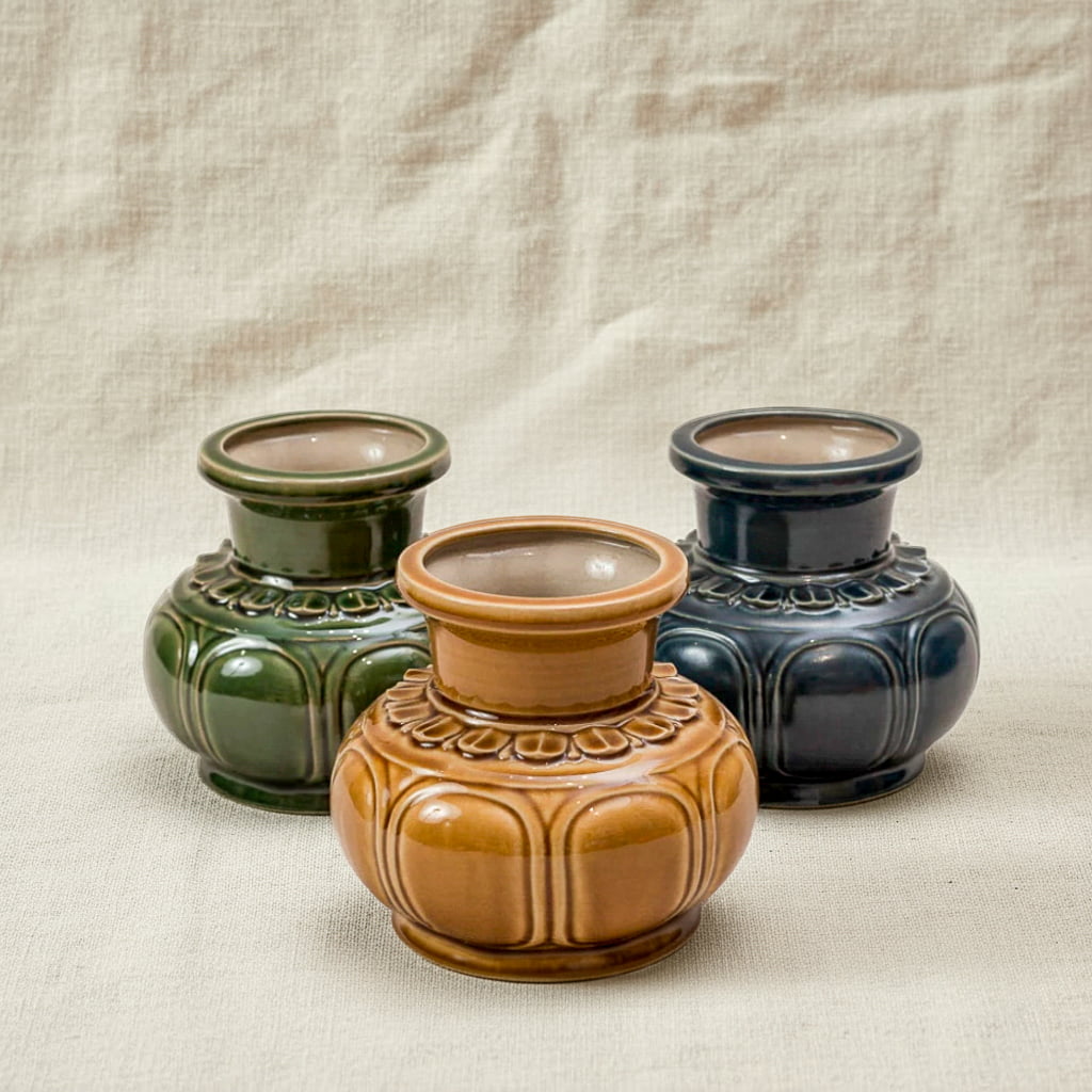 Three handmade ceramic flower vase options in green, brown, and blue. Each is a low wide flower vase.
