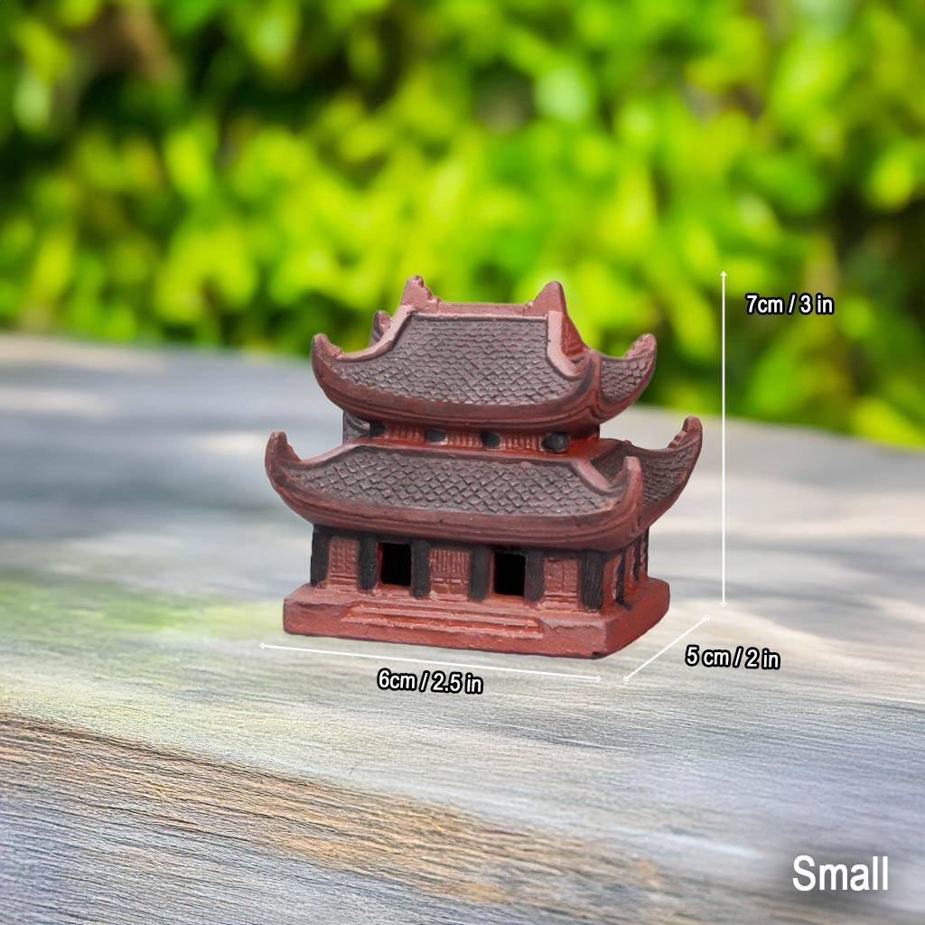 Small size Vietnam pagoda statue. A reddish-brown ceramic pagoda shown for scale on wood.