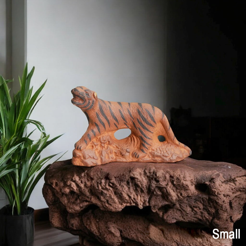 Small Ceramic Tiger Figurine on rock. Tiger miniature for bonsai decor. Plant background.