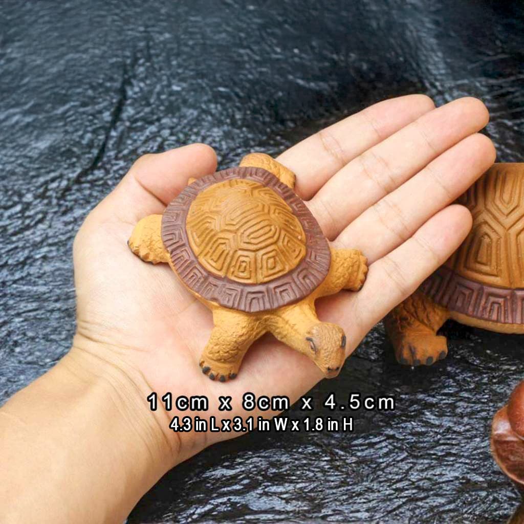 Hand holds a small, 11cm yellow and brown ceramic turtle figurine. Perfect for turtle decorations.
