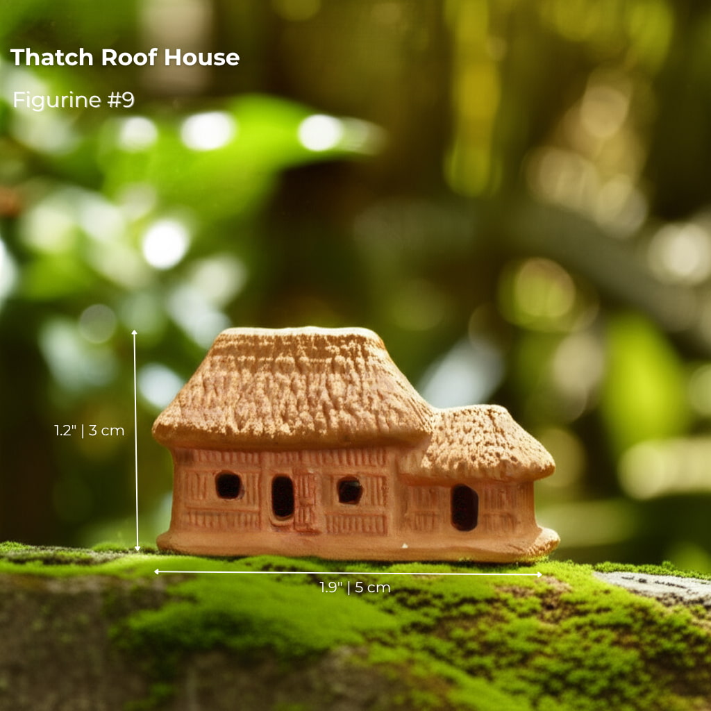 A small thatch roof house bonsai figurine sitting on moss. A rustic piece of bonsai decor.