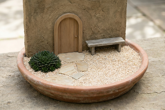 Restrained miniature courtyard with paving, a small doorway, bench, one plant and open gravel.