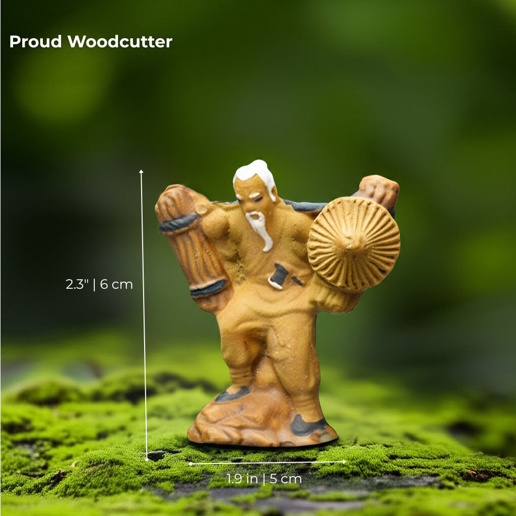 A standing Chinese mudmen figurine carries wood and a hat. A perfect bonsai decor accessory