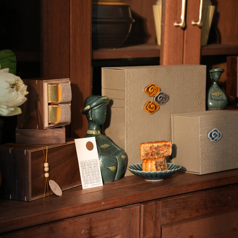 Duck-green Vietnamese woman figurine styled with mooncake gift boxes