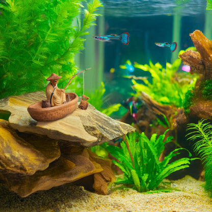  Nestled amongst colorful fish and lush aquatic plants, a miniature Vietnamese fisherman casts his line from a ceramic boat, adding a touch of cultural charm to this underwater oasis.