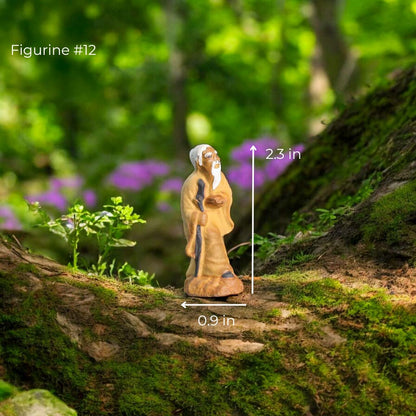 Small clay figure of an old man standing with a walking stick.
