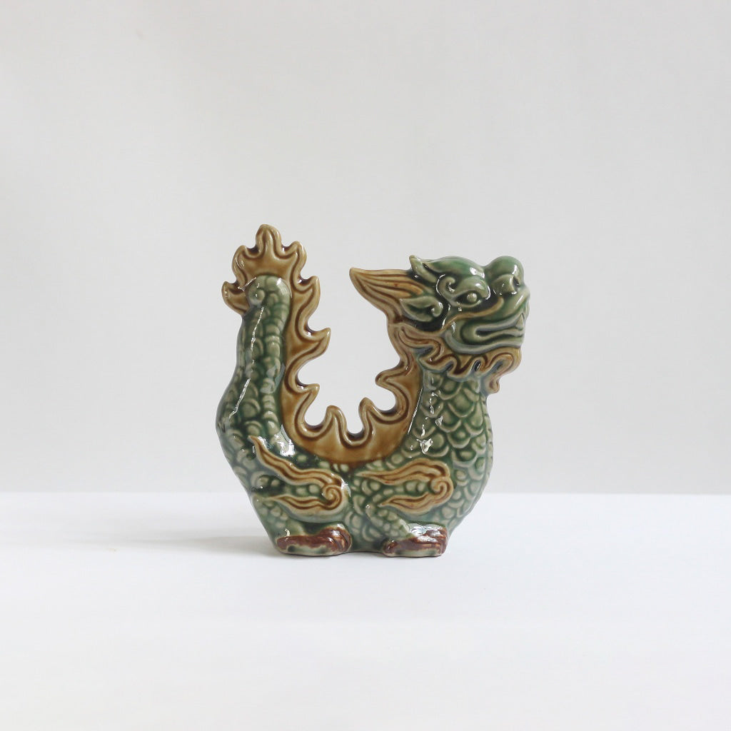 A celadon green dragon figurine with brown details. An artisan dragon sculpture Vietnamese.