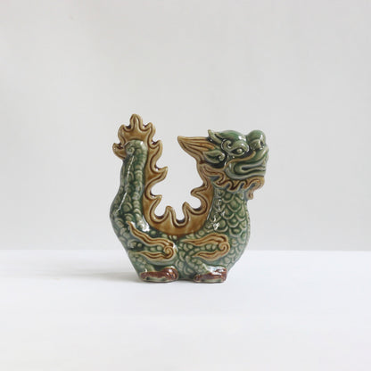 A celadon green dragon figurine with brown details. An artisan dragon sculpture Vietnamese.
