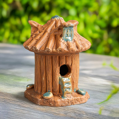  Handcrafted from natural clay, a charming fairy house, complete with a tiny door and a whimsical roof, sits amidst a lush green backdrop, perfect for adding a touch of magic to your bonsai or terr