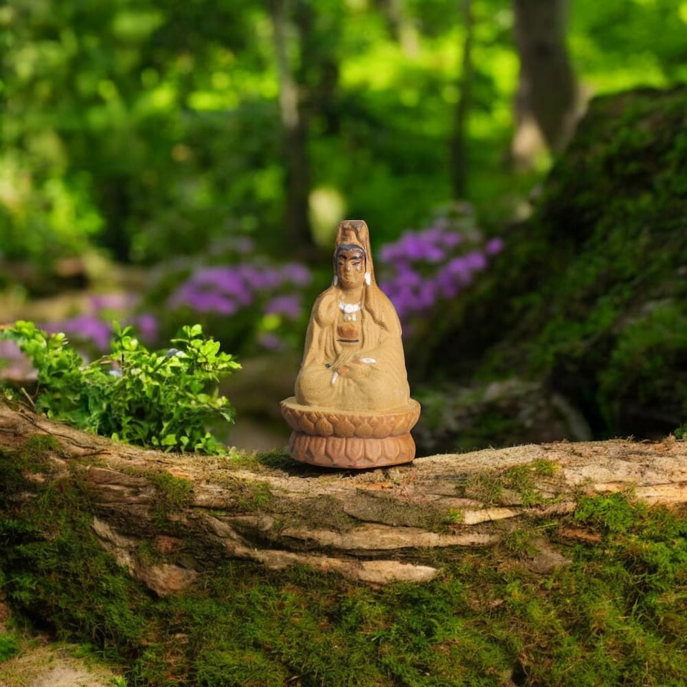 A small ceramic Quan Yin figurine sits on a lotus base, placed on a tree trunk.