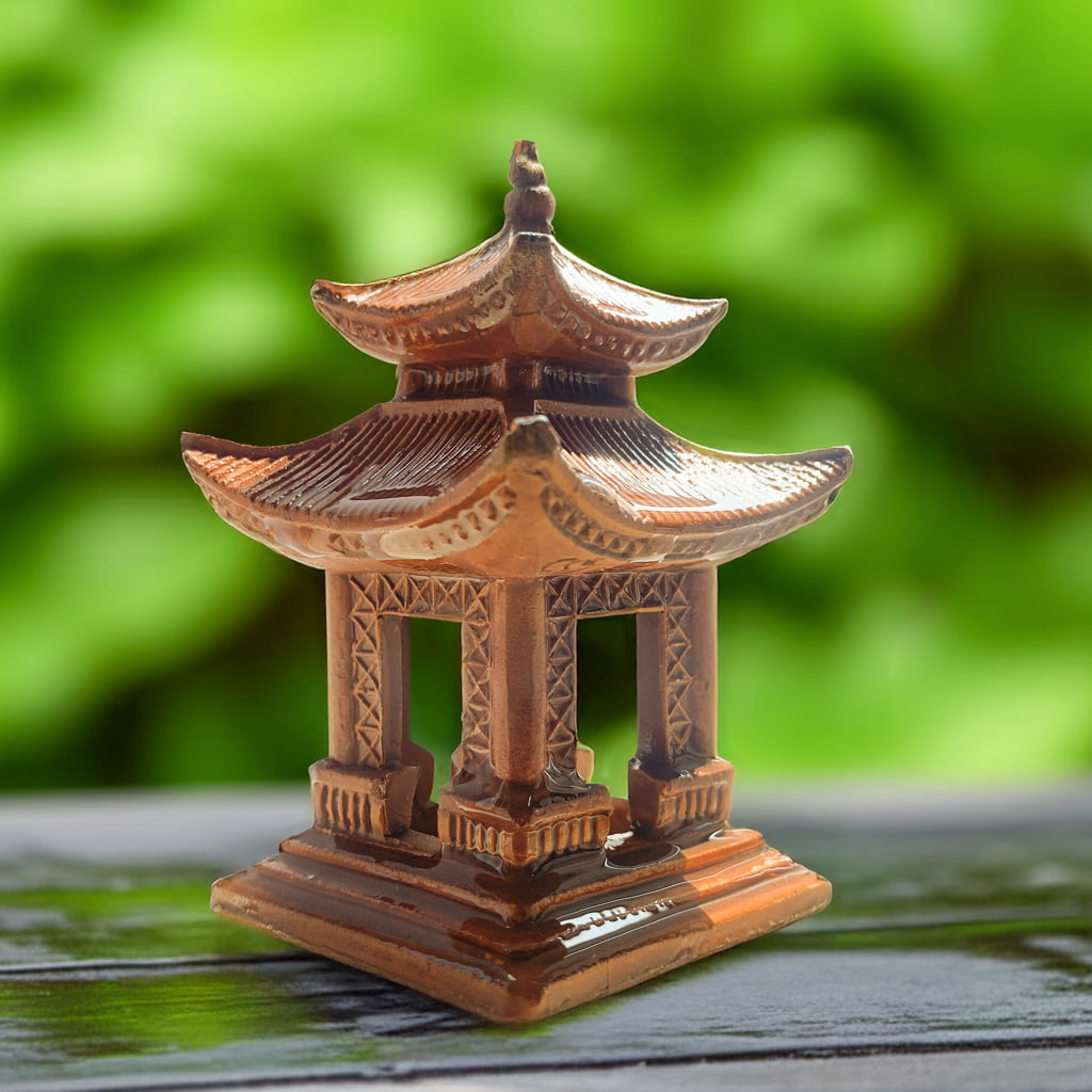 detailed ceramic pagoda for bonsai in wet weather on wooden table