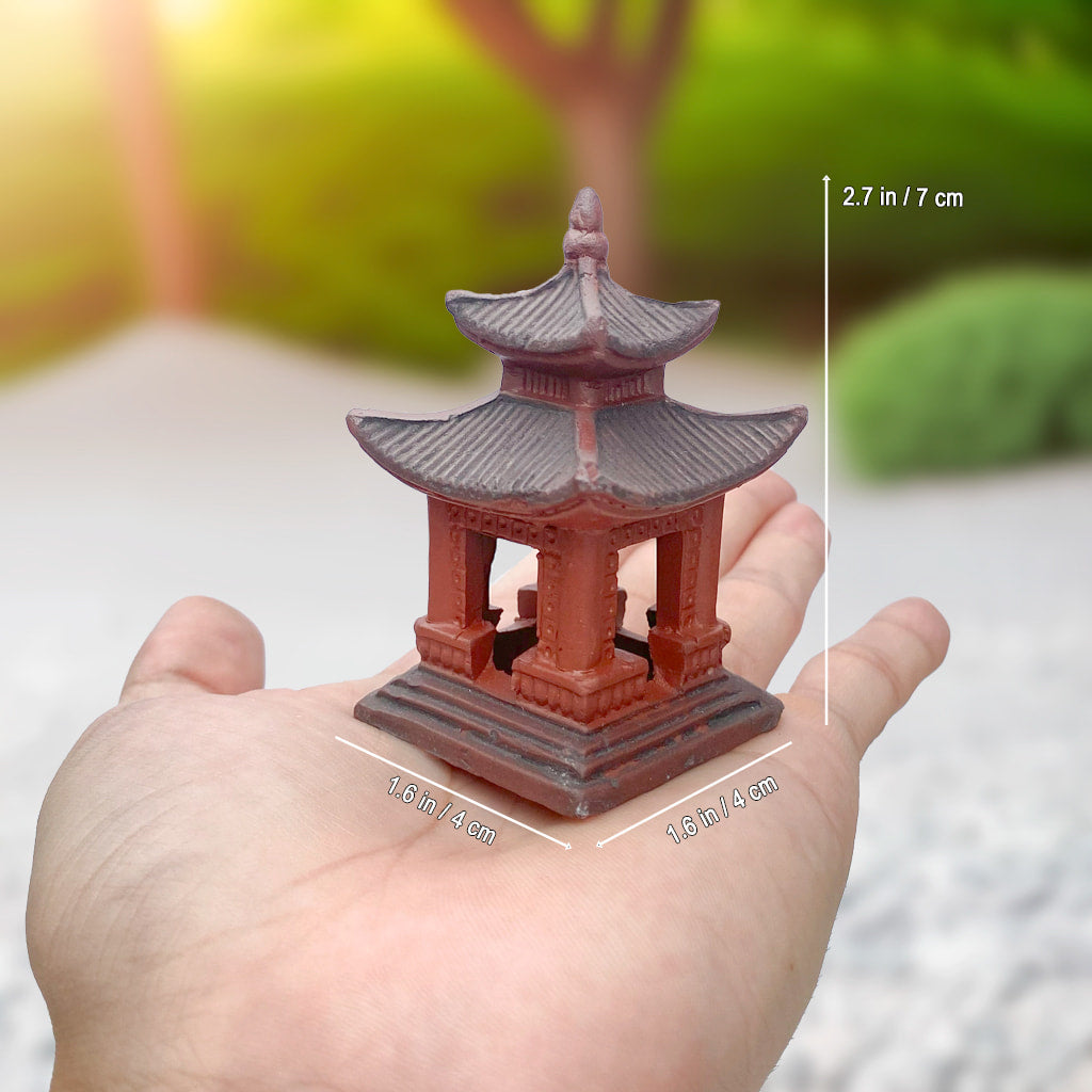 Hand holding small square ceramic pagoda for bonsai. A Zen garden pagoda statue for bonsai decor. 