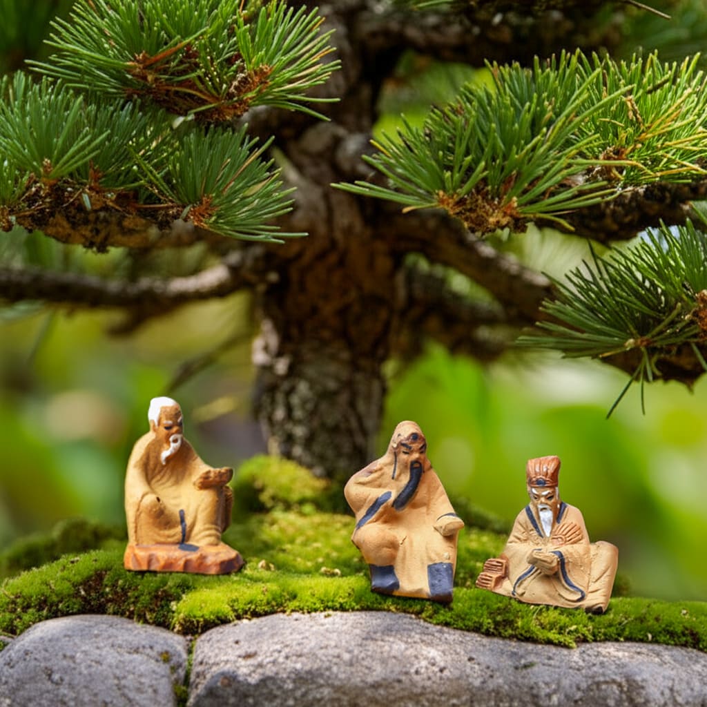 Three small bonsai mudmen sit on a mossy pagoda. These mudmen figurines are detailed bonsai decor.