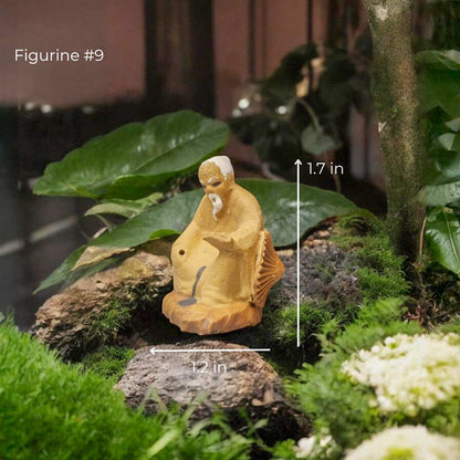 Tiny clay figurine of a seated, meditating old man with a long white beard.