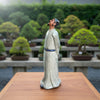 A side view of a ceramic figurine with a white crackle robe, a great choice for Bonsai decoration.