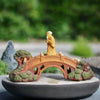  Mudman on a fairy garden bridge. This garden mini bridge is on a flat bonsai pot. 