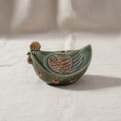 A side view of a green Vietnamese pottery rooster. This is a hand-painted rooster ceramic figurine