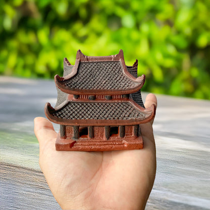 Held gently in a hand, this miniature ceramic pagoda, with its hand-painted details and rich brown hue, showcases the artistry and cultural heritage of Vietnamese ceramics.