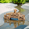 Brown wood-textured miniature bridge for garden over water; a fairy bridge reflecting. 