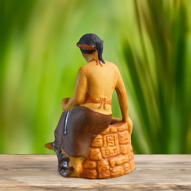 The back of a Tam figurine, her traditional Vietnamese dress intricately detailed, hints at the timeless stories woven into this handcrafted ceramic piece.