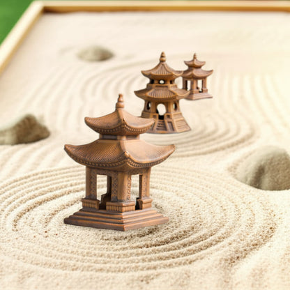 Three handcrafted pagoda statues arranged in sand, perfect Zen garden decor as Zen garden pagoda statue.