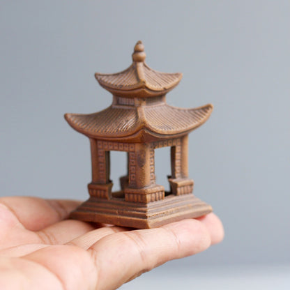 A hand holds the large square Bat Trang ceramic pagoda to provide a clear sense of its scale and handcrafted texture.