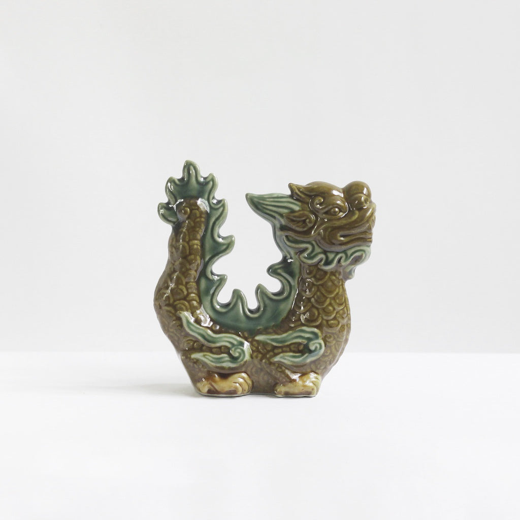 A brown-glazed Vietnamese ceramic dragon figurine with green accents. A protective dragon statue.