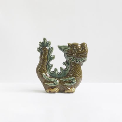 A brown-glazed Vietnamese ceramic dragon figurine with green accents. A protective dragon statue.