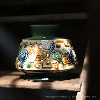  A handmade in Vietnam vase. This green centerpiece ceramic vase shows a detailed cloud motif. 