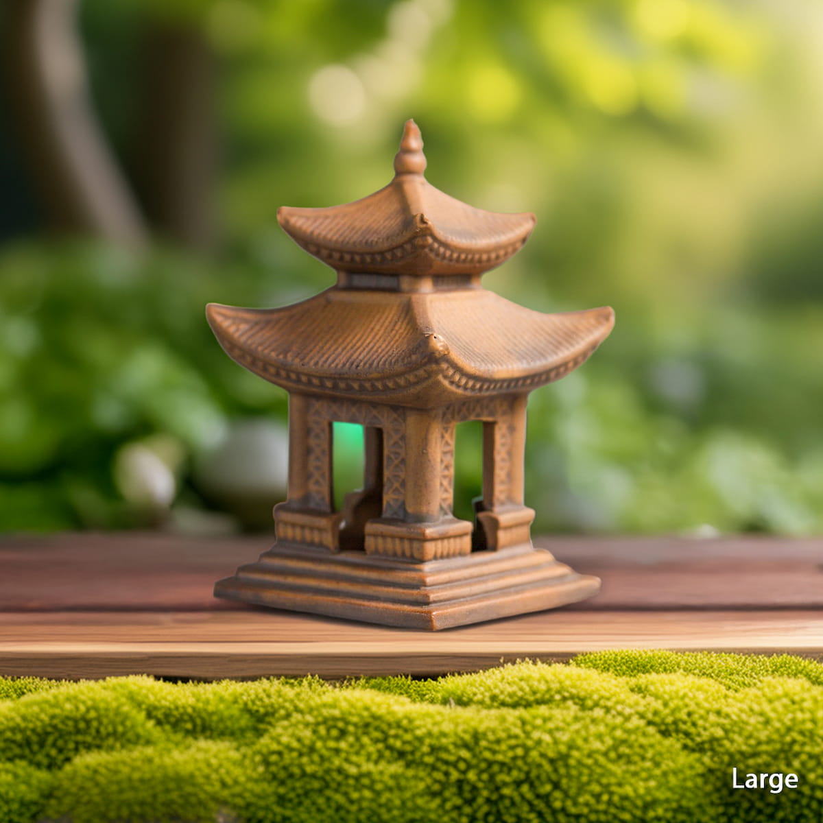 A larger brown clay pagoda statue sits on a wooden surface next to green moss. This miniature Japanese pagoda is ideal for bonsai decor or Zen garden decor.