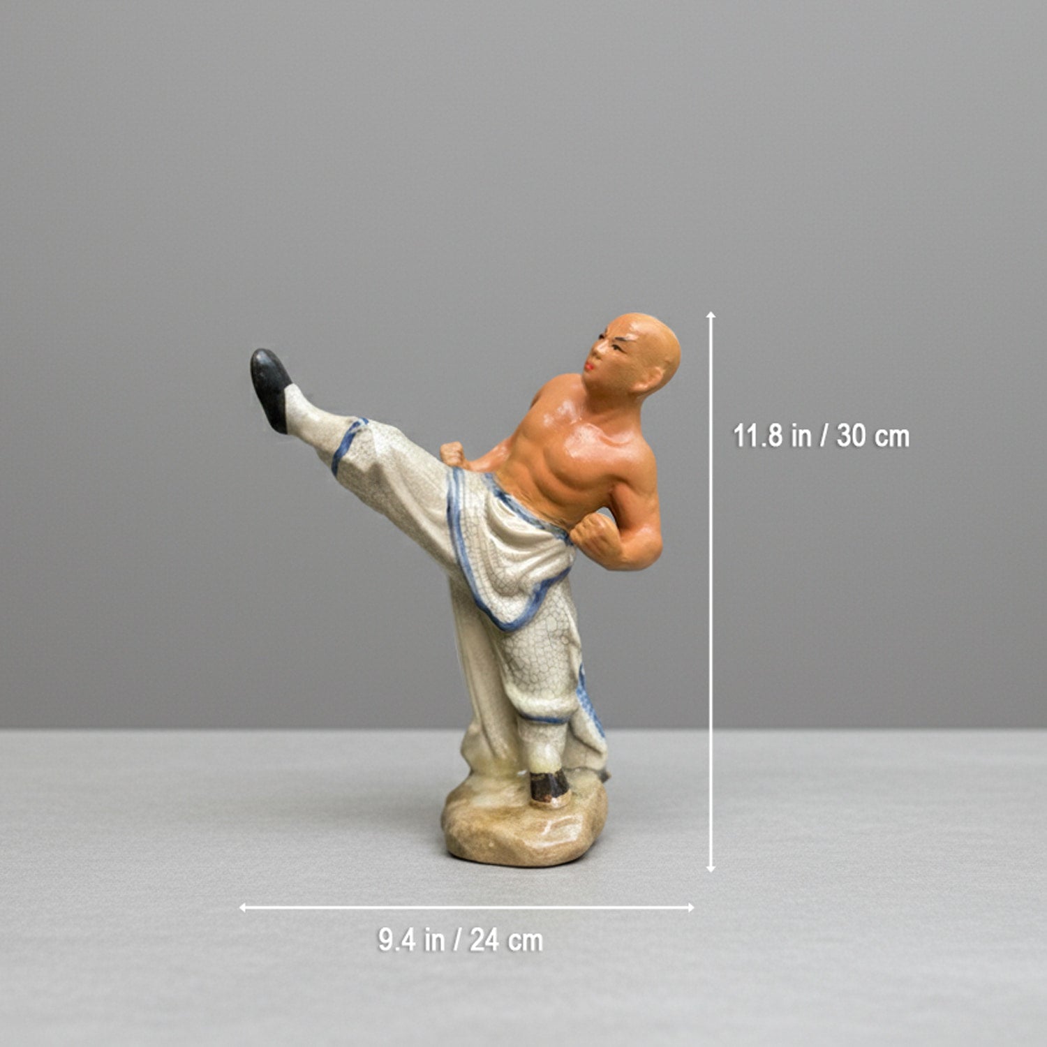 A kicking monk ceramic figurine shown with dimensions. A great miniature bonsai figurine.