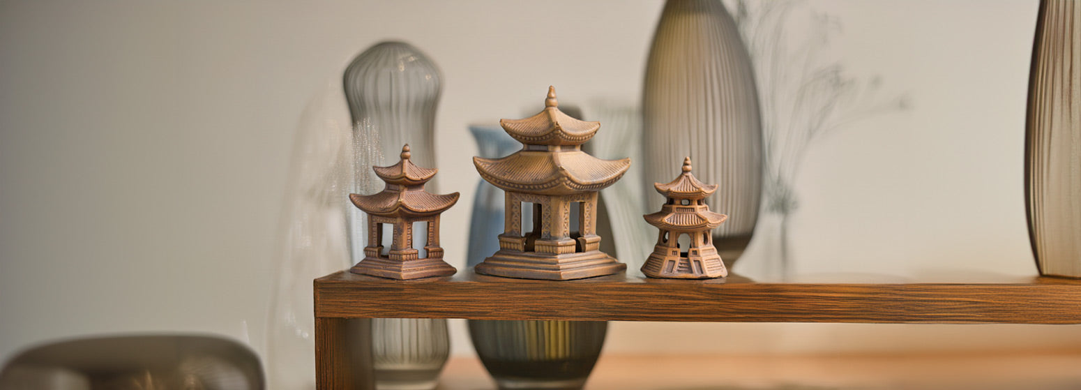 Three miniature ceramic pagodas, each with intricate details and a warm brown glaze, stand proudly on a wooden table, adding a touch of serenity to the modern decor.