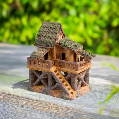 A charming miniature treehouse, meticulously crafted from Bat Trang ceramic, stands tall on stilts, its thatched roof and tiny balcony beckoning you to a world of imagination.