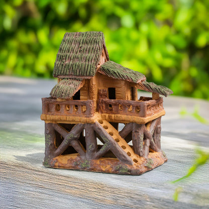 A charming miniature treehouse, meticulously crafted from Bat Trang ceramic, stands tall on stilts, its thatched roof and tiny balcony beckoning you to a world of imagination.