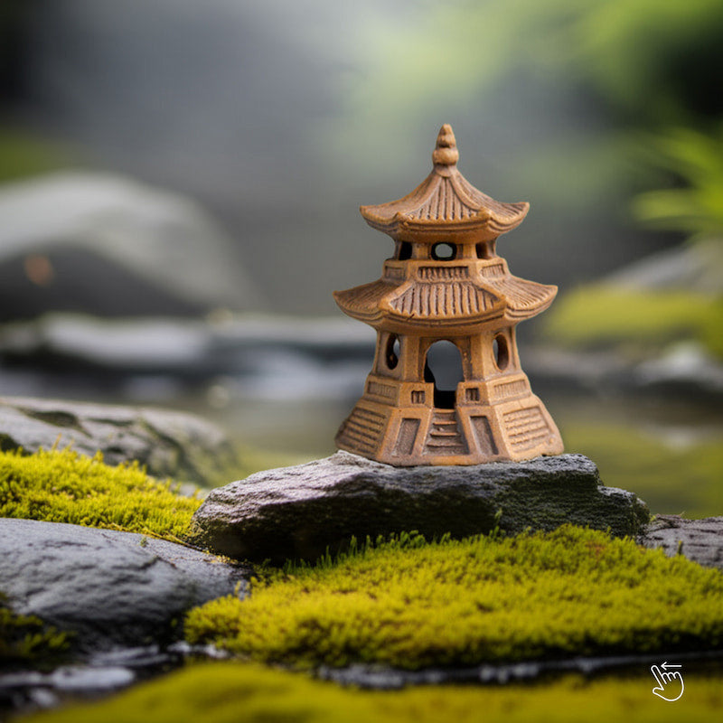  A single miniature japanese pagoda sits on a mossy rock, a perfect bonsai figurine for zen garden decor.