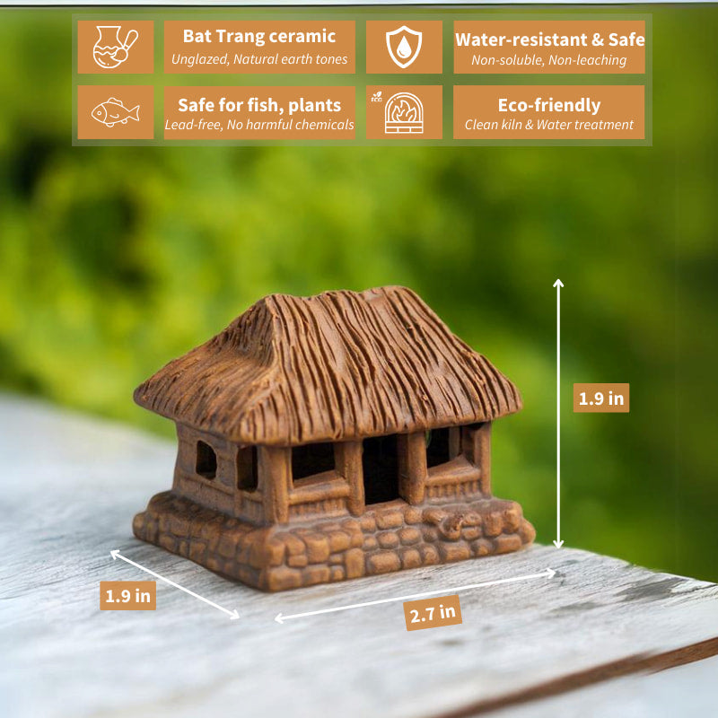 A charming miniature thatched house, crafted from rustic brown ceramic, sits peacefully on a wooden surface, bringing a touch of Vietnamese tradition to any space