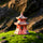 A three-tiered miniature pagoda made of reddish Hoang Tho clay sits atop a lush green moss mound. The ceramic structure features grey-toned roofs and small arched windows, surrounded by smooth black river stones in a zen garden decor setting.