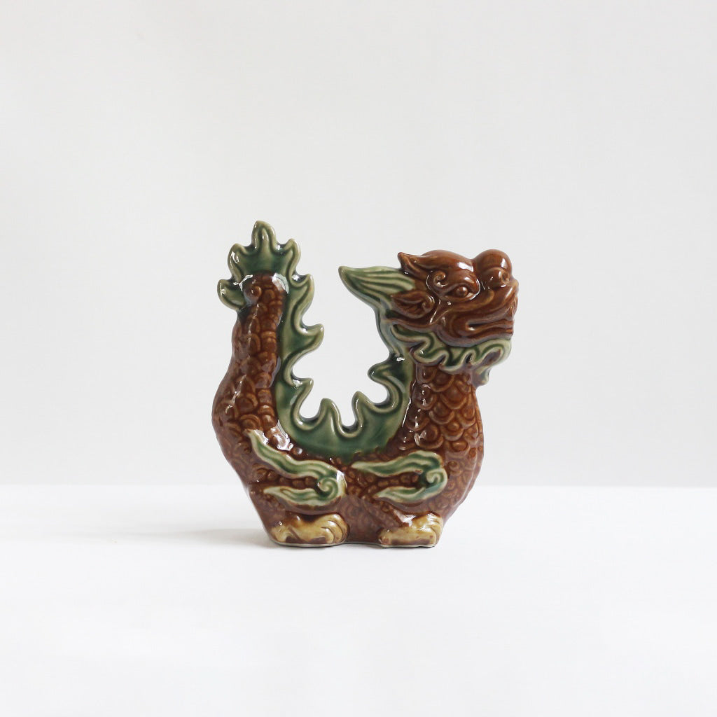 A red-brown glazed Asian dragon figurine. This handmade ceramic dragon is great for home decor.