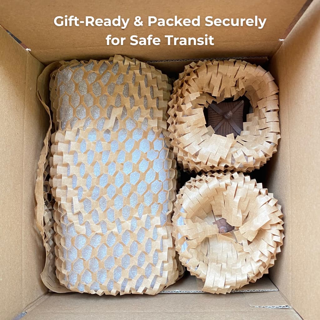 An open shipping box showing the Bat Trang ceramic pagoda figurines securely wrapped in brown protective honeycomb paper, ensuring they arrive safely.