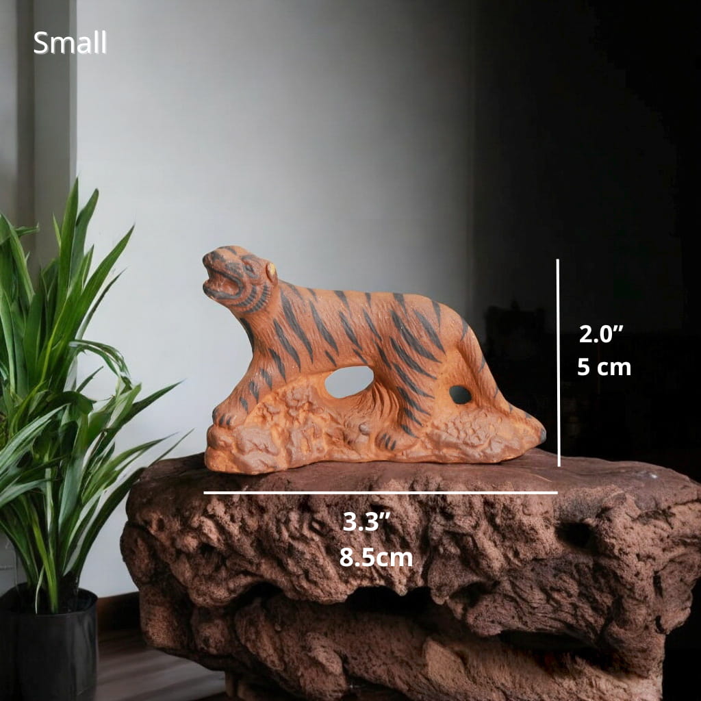 Small Ceramic Tiger Figurine on rock. Tiger miniature for bonsai decor. Plant background.